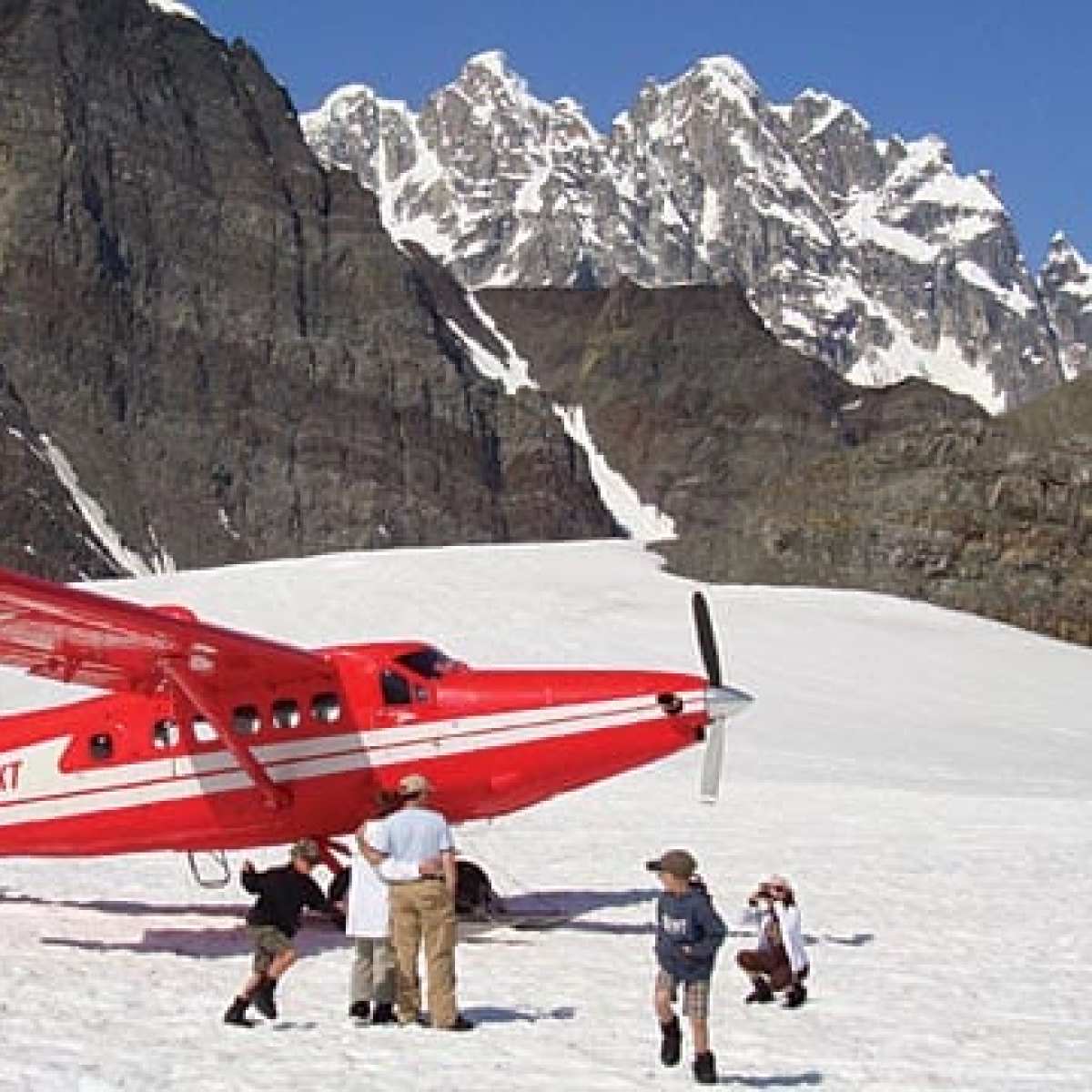 a group of people standing on top of a snow covered mountain