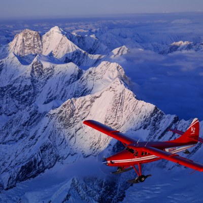a plane flying over a snow covered mountain