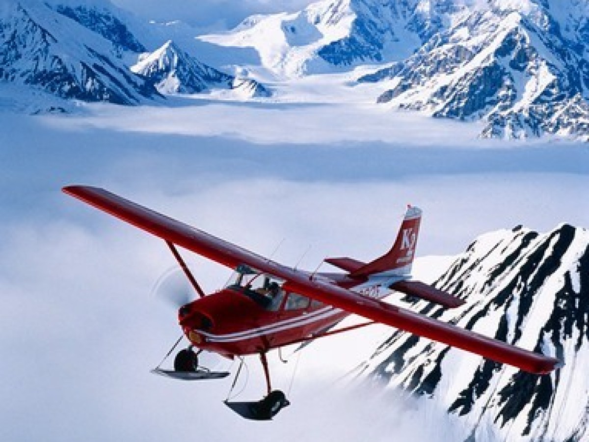 a plane flying over a snow covered mountain