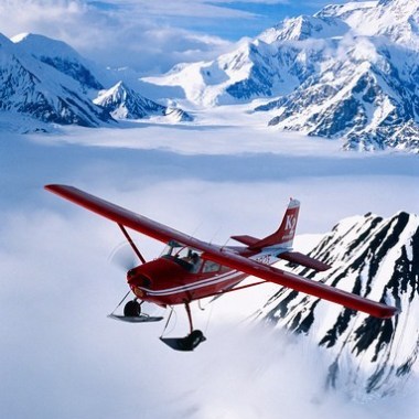 a plane flying over a snow covered mountain