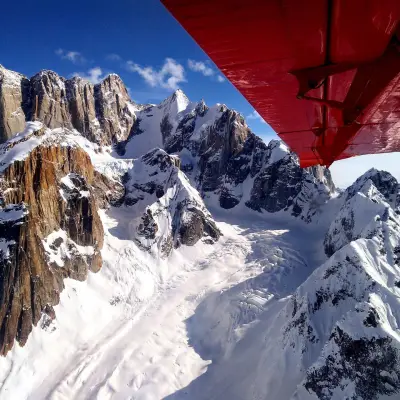 a man flying through the air on a snow covered mountain