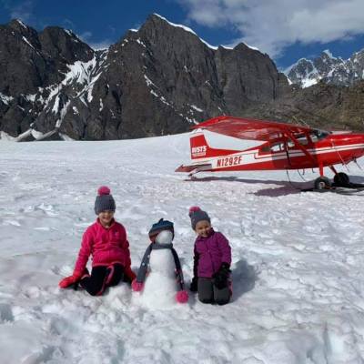 a group of people standing on top of a snow covered mountain