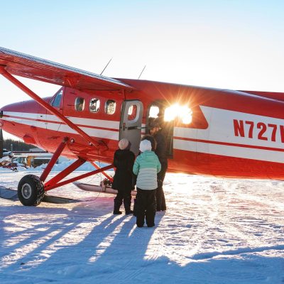 a man standing in front of a plane in the snow