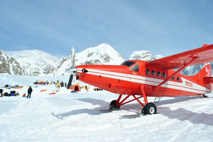 a plane sitting on top of a snow covered mountain