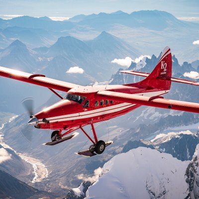 a plane flying over a snow covered mountain