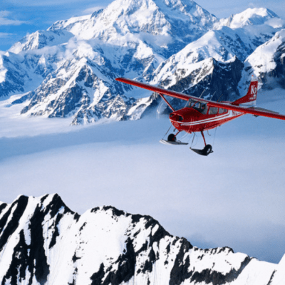 a plane flying over the snowy mountains