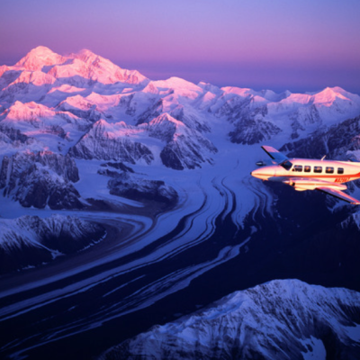 a plane flying over a snow covered mountain