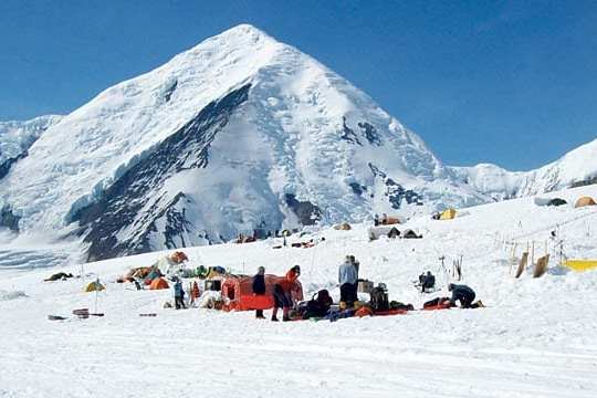 a group of people standing on top of a snow covered mountain