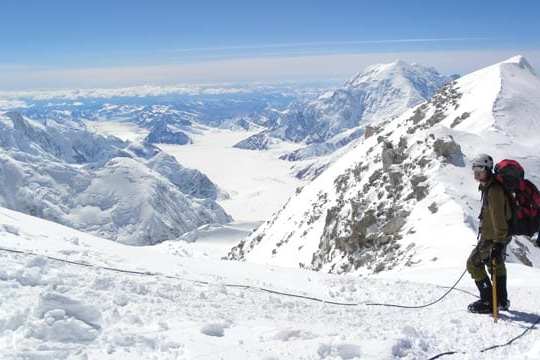 a group of people standing on top of a snow covered mountain