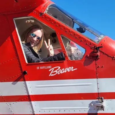 a woman posing outside a plane