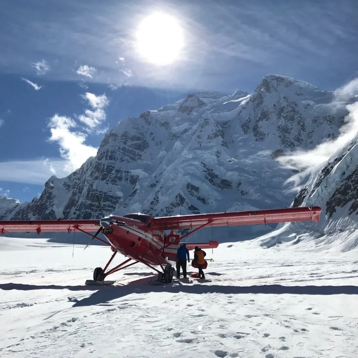 a group of people riding skis on top of a snow covered mountain