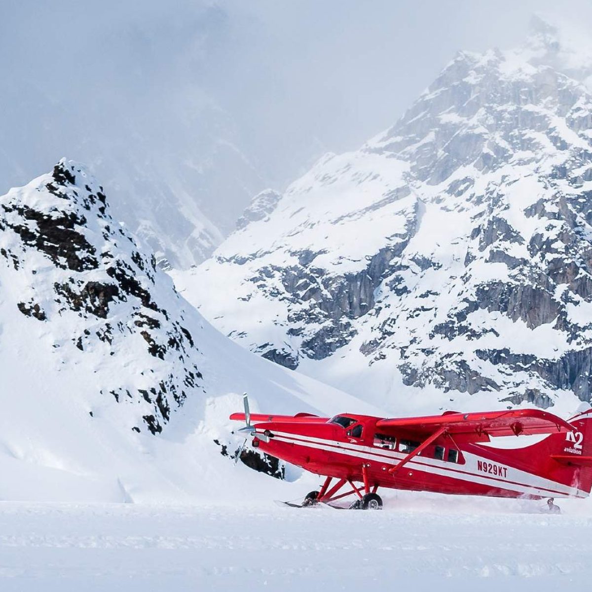 a man riding skis down a snow covered mountain