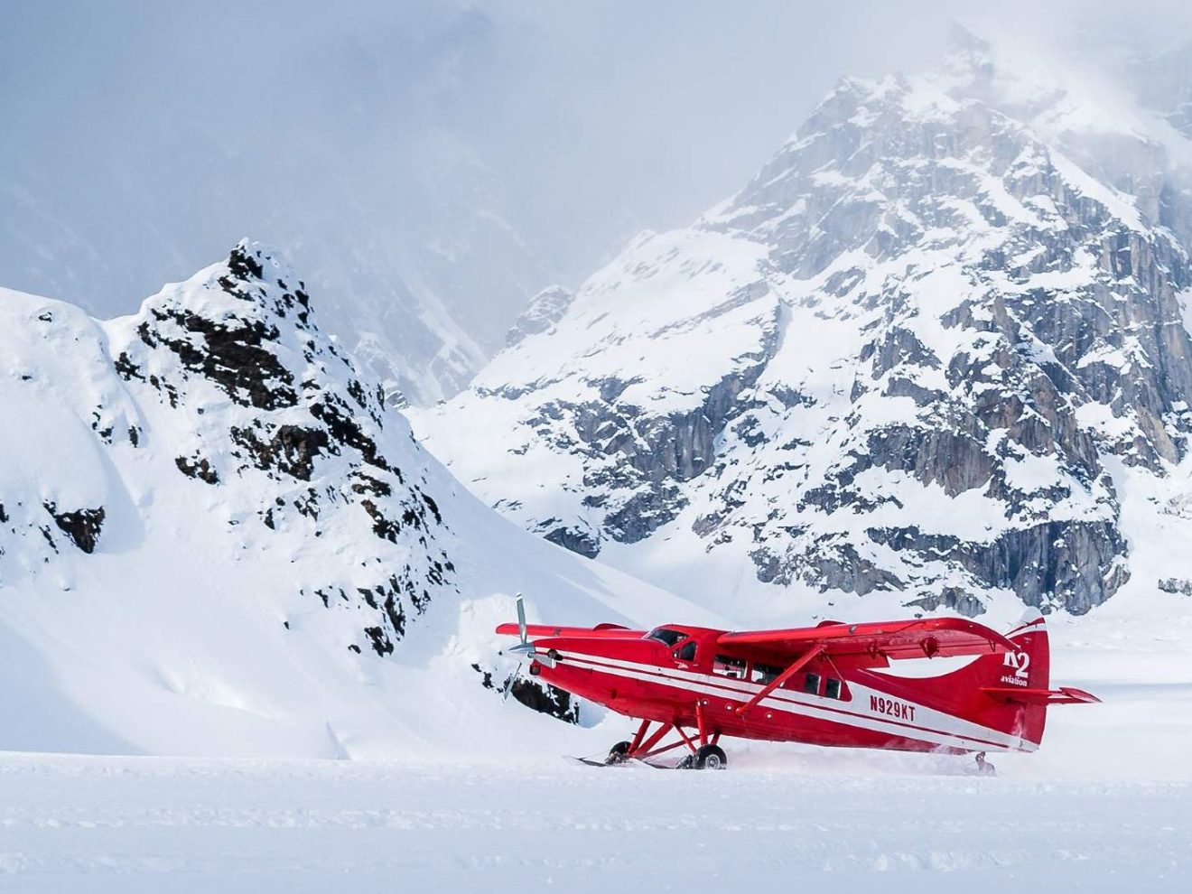 a man riding skis down a snow covered mountain