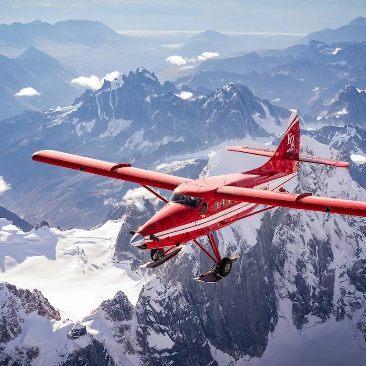 a man flying through the air on a snow covered mountain