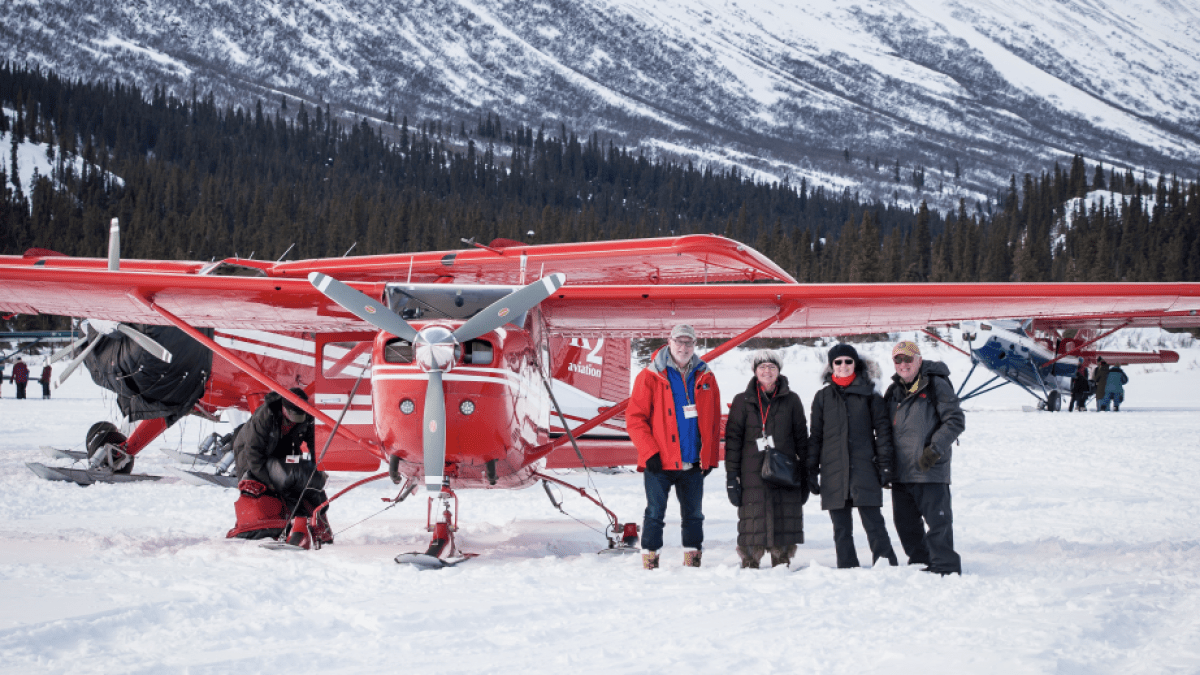a group of people standing on top of a snow covered mountain