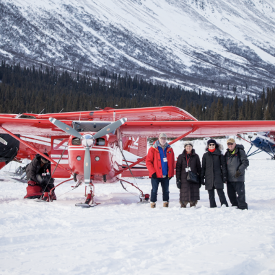 a group of people standing on top of a snow covered mountain